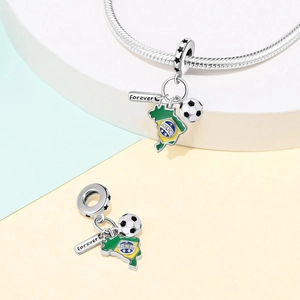 Macro detail of Brazil map pendant, football charm, and 'forever' engraved tag on a bead