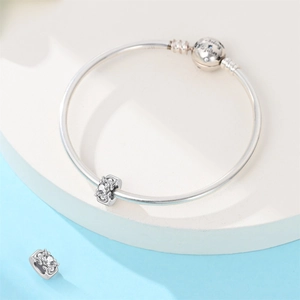 Macro shot of silver sterling charm bracelet with We belong together engraved sphere