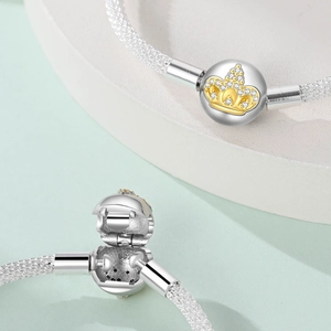 Macro detail of S925 sterling silver mesh bracelet featuring a gold crown clasp and stones