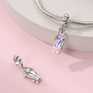 Macro shot of silver S925 love charm and colorful floral bouquet bead with pink bow