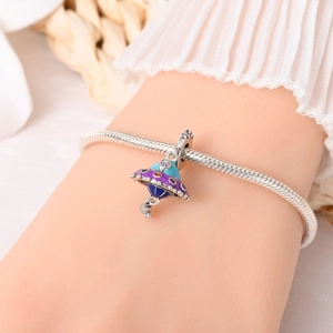 Detailed close-up of a 925 silver snake chain bracelet with UFO and alien planet charm
