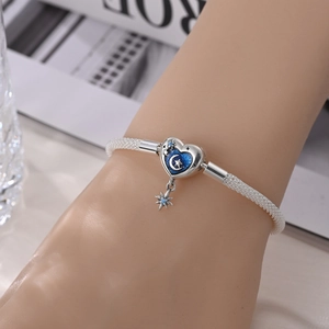 Silver plated mesh bracelet with blue enamel heart charm and star moon dangle on wrist