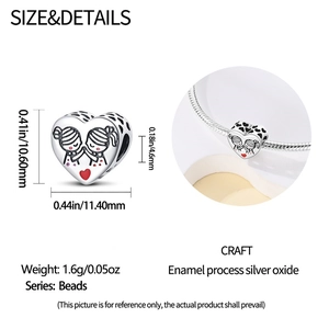 Macrodetail van zilveren hartkraal met rood email en figuren voor DIY-bedelarmbanden