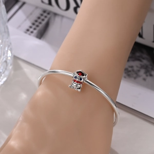 Silver open bangle with graduation charm featuring a red cap and Finished engraving
