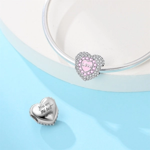 Macro shot of silver heart charms with Love and You are the best for me engravings