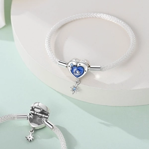 Macro detail of S925 sterling silver mesh bracelet with blue celestial heart clasp