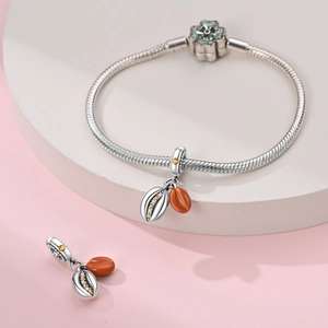 Nahaufnahme von Silber Schlangenarmband mit Kleeblatt-Verschluss und Meeresmuschel-Anhänger