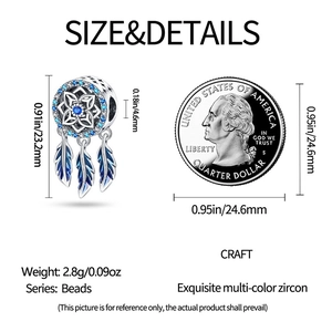Macro detail of silver dreamcatcher charm with blue zircon and feathers next to coin