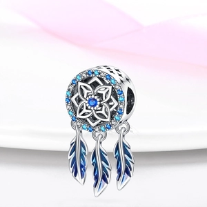 Macro detail of silver dreamcatcher charm with blue stones and feather pendants