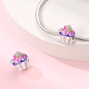 Silver cupcake charms with pink enamel and crystals on a snake chain bracelet