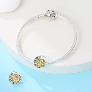 Macro shot of silver sunflower and moon charm with 'We belong together' engraved clasp