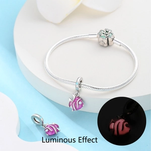 Détail du charm poisson tropical lumineux sur bracelet serpent argenté avec lueur