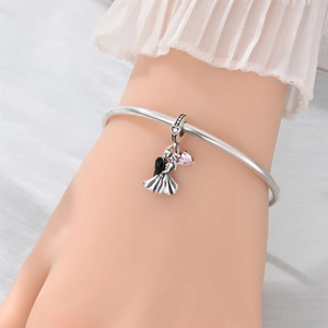 Detail of silver couple charm with pink heart gemstone on a minimalist bangle