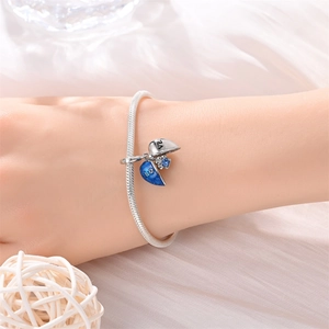 Silver snake chain bracelet featuring blue enamel heart charms and crystal detail