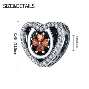 Macro shot of silver heart charm with orange clover stones and 11.8mm size detail