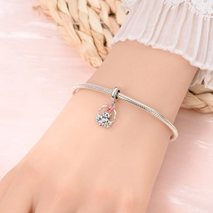 Gros plan détaillé d'un bracelet maille serpent en argent avec un pendentif chat rose