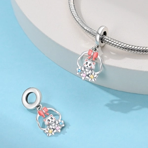 Détail du charm chat en argent avec nœud en émail rose et gemmes colorées sur bracelet