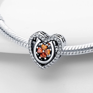 Silver horseshoe charm with orange clover heart zircon on snake chain bracelet
