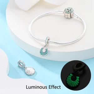 Détail du charm coquillage argenté et fermoir floral avec effet lumineux vert