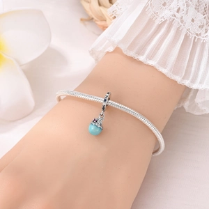 Macro détaillée d'un bracelet serpent argenté avec un charm lumineux bleu