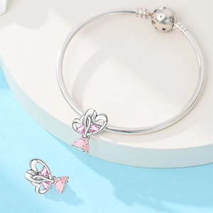 Silver charm bracelet with pink zircon heart and car pendant on a blue geometric stand
