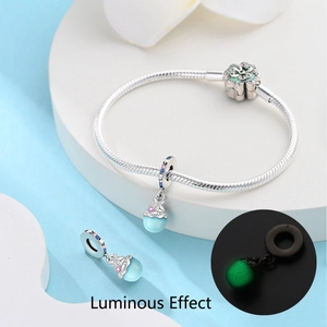 Charm tortue lumineuse sur bracelet en argent montrant l'effet fluorescent dans le noir