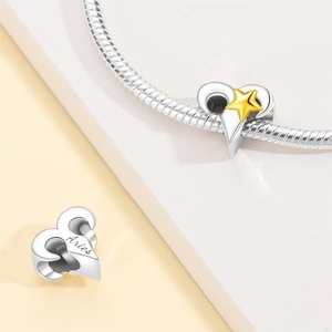 Macro detail of Aries zodiac charm with gold star and engraving on silver snake chain