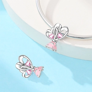 Detailed view of silver charm with pink enamel car and heart zircon on a bracelet
