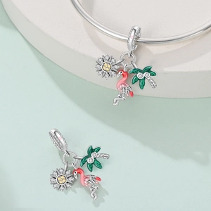 Detail of silver tropical charm set with flamingo palm tree and sunflower elements
