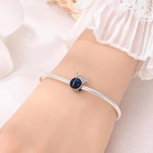 Détail du bracelet en chaîne serpent argentée avec breloque renne et verre étoilé bleu