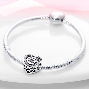 Macro shot of silver snake chain bracelet with pink zircon paw heart charm and clasp