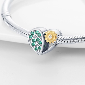 Macro shot of 925 silver sunflower charm with green zircon leaf on a snake chain