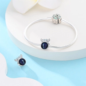 Détail du bracelet chaîne serpent argentée avec pendentif bleu et design de bois