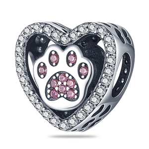 Detailed macro view of heart-shaped charm with pink gem paw print and silver plating