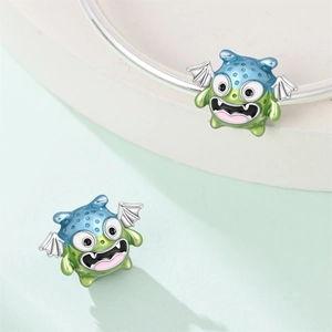 Detailed macro of a monster bead with blue-green enamel and silver wings on a bracelet