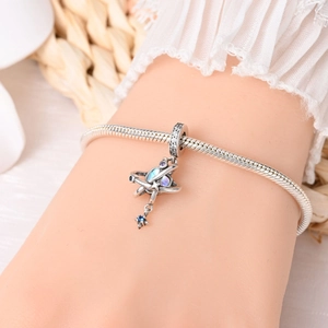 Starry sky planet charm on silver snake chain bracelet shown on a woman's wrist