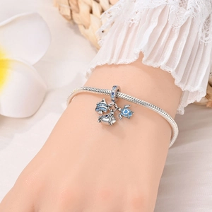 Dettaglio del bracciale in argento con ciondoli a tartaruga marina e pesci
