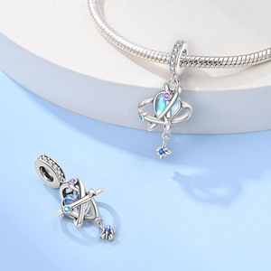 Detailed view of silver planet charm with blue crystal and small purple cubic zirconia