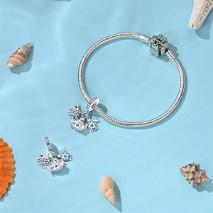 Dettaglio dei ciondoli marini tartaruga e pesce blu su bracciale a catena serpente argento