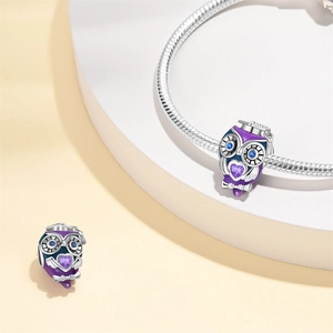 Détail du charm hibou en émail violet et pierres de zircon sur bracelet serpent
