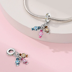Close-up of three-color candy charms in blue, pink and caramel with zircon stones