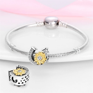 Close-up of horseshoe charm with gold sunflower and heart cut-outs on silver bracelet