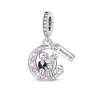 Detailed macro of wedding charm with bride and groom on a crescent moon pendant