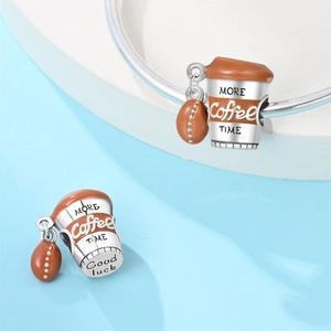 Makro-Detail von Kaffeetassen-Charm mit Emaille und Kaffeebohnen-Anhänger für DIY-Armbänder