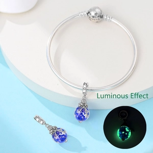 Detailed close-up of silver snake chain bracelet with blue luminous charm bead effect