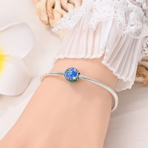 Dettaglio del bracciale oceano in argento con ciondoli a stella marina e palma blu