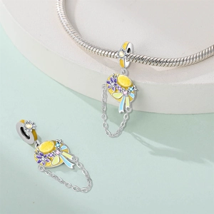 Detail of a yellow enamel sun hat charm with colorful floral accents on a silver bracelet