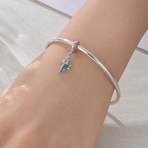 Detail of silver conch charm with teal enamel and crystals on a fine bangle bracelet