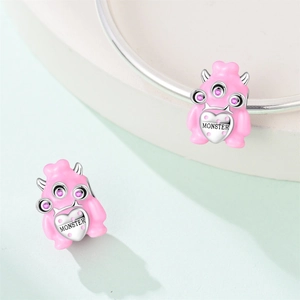 Macro shot of pink monster charm with MONSTER engraving and purple zircon on silver heart