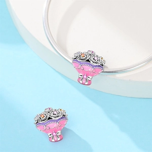 Macro detail of bouquet charms with pink enamel roses and sparkling zircons for bracelets